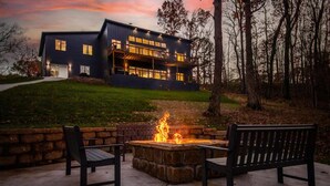 A modern house with a fire pit and two chairs in the foreground. - Welcome to PEDAL AND PLUNGE (Bella Vista)