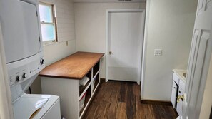 Un lavadero con lavadora, secadora y encimera de madera.
