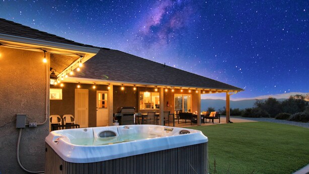 Un bain à remous dans un jardin, sous un ciel étoilé.