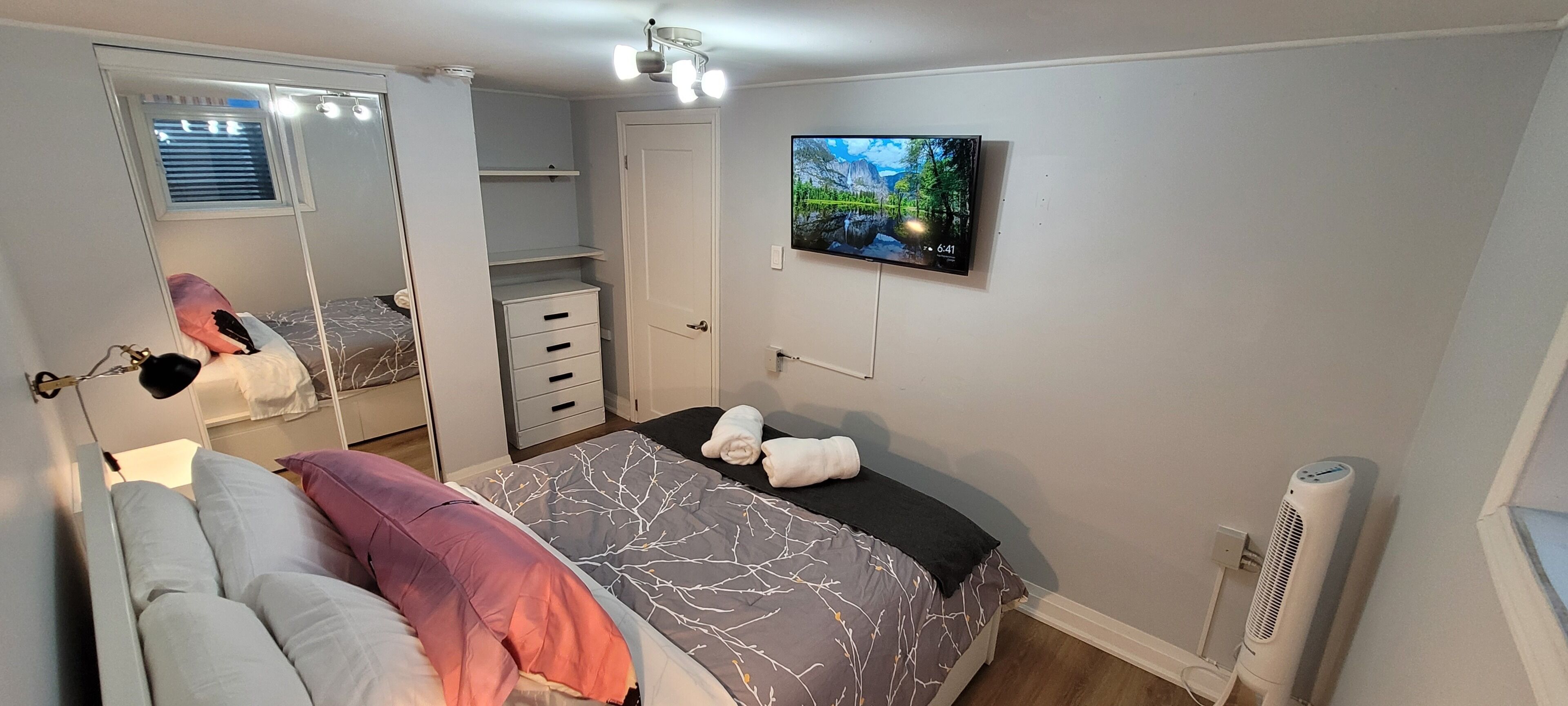 A bedroom with a bed, a TV, a wardrobe, and a heater.