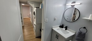 Une salle de bain moderne avec un lavabo, un miroir et un porte-serviettes.