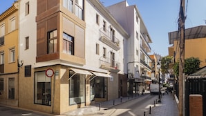 Vista de la calle con un edificio que tiene una tienda en la planta baja y apartamentos en los pisos superiores.
