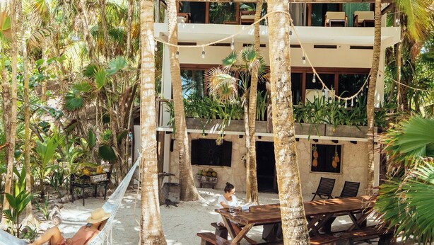 A resort with a pool area, outdoor seating, and a hammock. - Olas Tulum (Tulum)