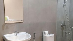 A bathroom with a sink, toilet, and shower. - Hotel Marina Airport (West Semarang)