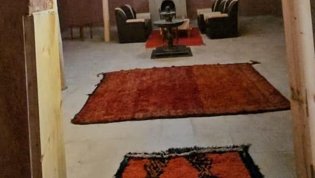 An interior space with a central area featuring a chandelier, two sofas, and a rug. - Hôtel-Kasbah Aberdouz (Ait Yahya)
