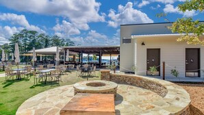 An outdoor patio area with stone seating, tables, and umbrellas. - Stoneview Lakeside Dreams, 3BR Stillwaters Lake Condo (Alabama)