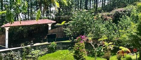 A lush garden with a gazebo, benches, and a variety of plants.