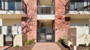 A building with a brick facade, a gated entrance, and a mailbox.