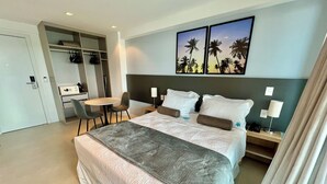 A hotel room with a large bed, a desk with a chair, a small table, and a wall-mounted TV. - RN STUDIO - APTO 903 (Maceio)