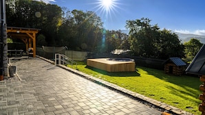 A patio area with a fire pit, a wooden pergola, and a grassy lawn. - Villa in Bohemia With hot tub (Dolní Podluží)