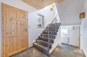 A wooden door, a staircase with metal railings, and a window with a plant. - Villa in Bohemia With hot tub (Dolní Podluží)
