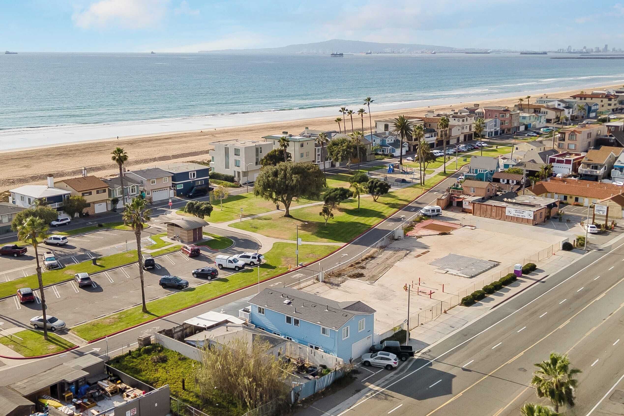Zona residencial à beira-mar, com vista para a praia, casas e estacionamento.