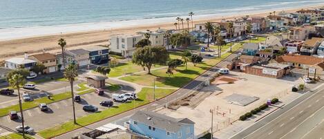 Zona residencial à beira-mar, com vista para a praia, casas e estacionamento.