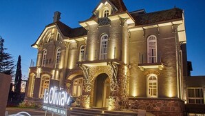 A large, historic building with a stone facade, arched windows, and a prominent entrance. - La Olivia Hotel Boutique & Spa (La Falda)