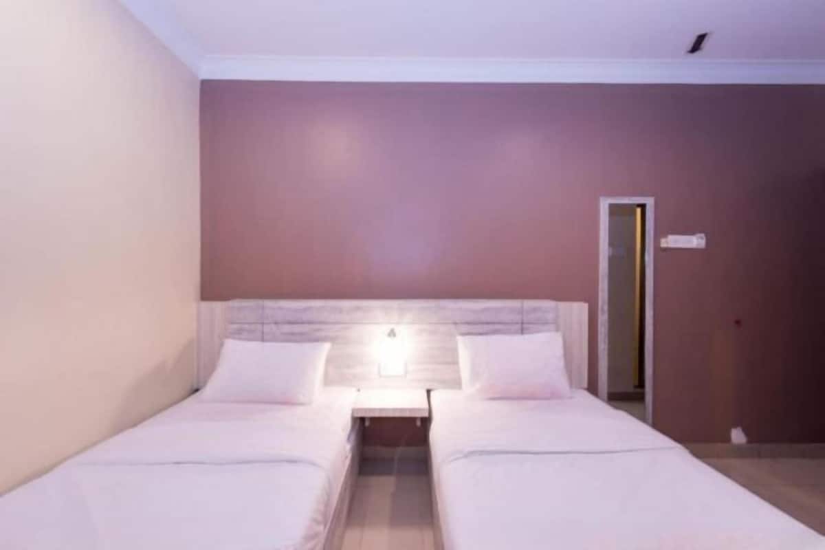 A single bed with a headboard, a bedside table, and a nightstand.