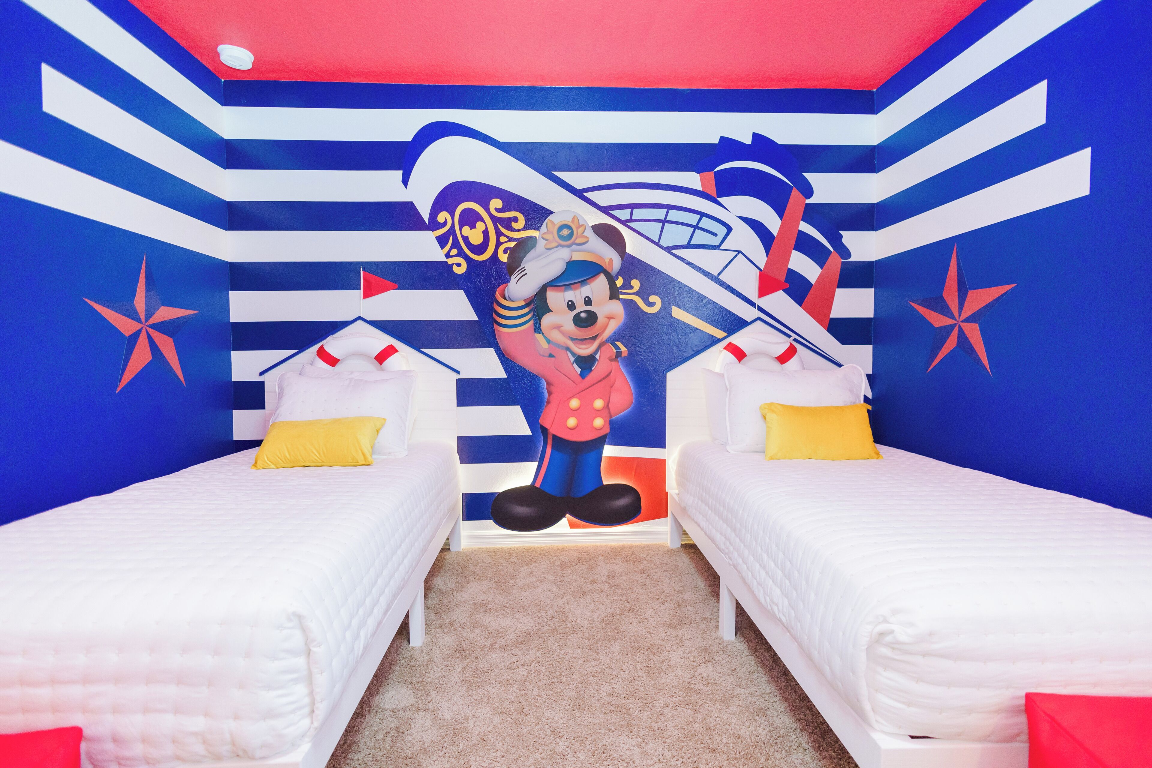 A room with two beds, a large mural, and a star decoration.