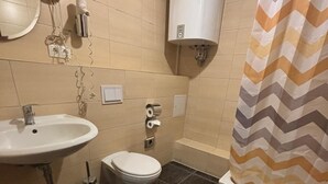 Une salle de bain équipée d’un lavabo, de toilettes et d’un rideau de douche.