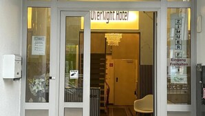 L’entrée de l’hôtel OverNight, avec un grand panneau portant le numéro 79 au-dessus de la porte.