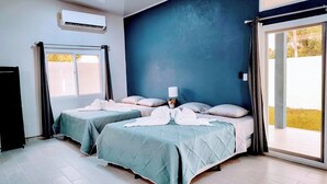 Una habitación de hotel con dos camas, un ventanal grande y un equipo de aire acondicionado.