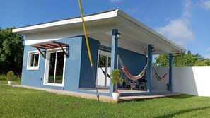 A single-story house with a covered porch, a hammock, and a potted plant. - Modern Cozy Villa in awesome Tela close to Beach (Tela)