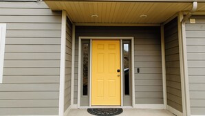 A house with a yellow front door, a small porch, and a doormat. - Spacious 5-bedroom townhome in Moscow (Moscow)