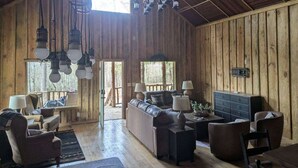 A rustic wooden interior with a sofa, chairs, and a dining table.