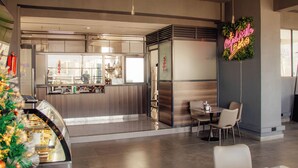 A modern cafe interior with a neon sign, a glass display case, and a seating area. - 1 bedroom spacious, modern and cozy apartment nestled in upperhill nairobi Kenya (Nairobi)