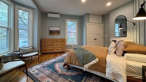 A bedroom with a large bed, a dresser, a chair, and a window. - Wander & Wonder: A Hidden Gem in Portland’s Heart (Portland)