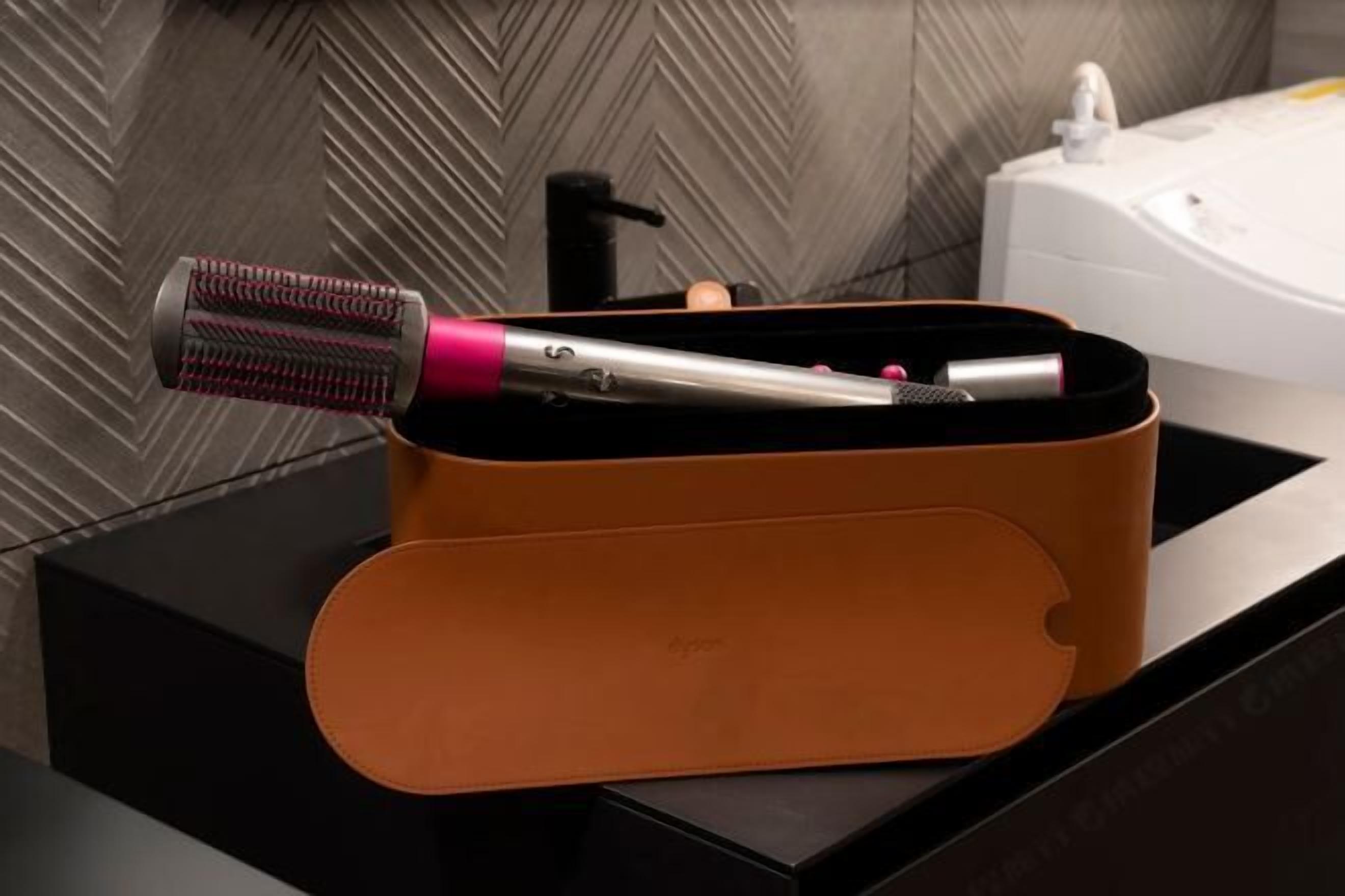 Un baño de diseño moderno, con encimera negra, compartimento de almacenamiento de cuero marrón y bañera blanca.