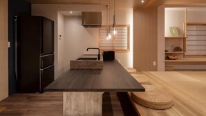 Una cocina moderna con una mesa de madera oscura, electrodomésticos integrados y un diseño minimalista.