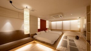 Un dormitorio moderno con una cama grande, una mesita de noche, una lámpara y un aire acondicionado instalado en la pared.