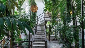Eine Treppe, umgeben von üppigem Grün, die zu einer erhöhten Ebene führt.