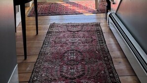 A spacious hallway with a large window leading to a deck, a staircase, and a patterned rug on the floor. - Large Farmhouse with expansive views, firepit 15 min north of Keene (Walpole)