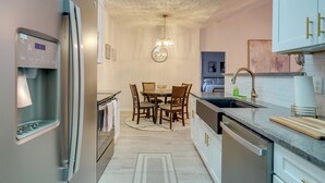 Una cocina moderna con refrigerador, lavamanos y comedor.