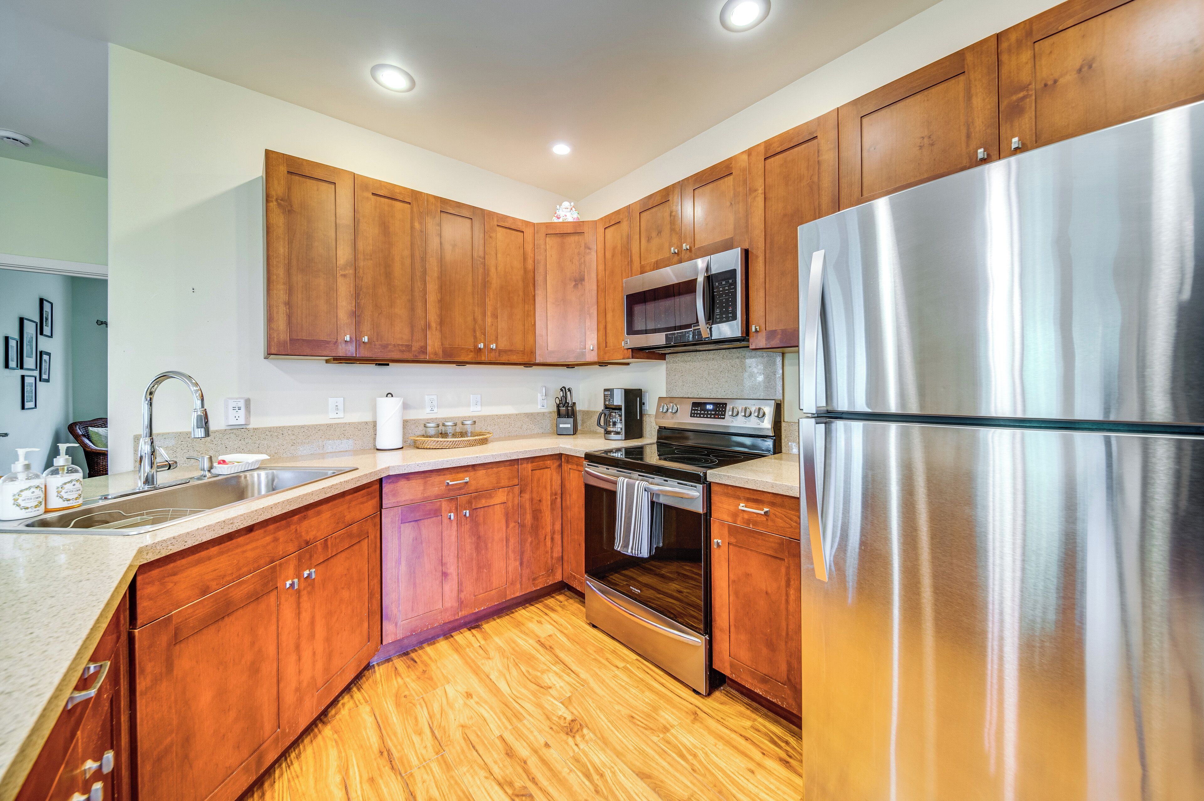 A modern kitchen with wooden cabinets, stainless steel appliances, and a granite countertop.