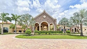 A large building with a stone facade, multiple arches, and a central dome. - Estate Bungalow With TPC golf course. Luxury, in and out. (Naples)