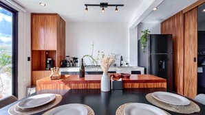 Une cuisine moderne dotée d’un îlot central, de meubles en bois et d’un réfrigérateur noir.