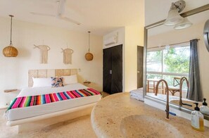 Relax in a spacious room with a large bed and a stylish sink area.
