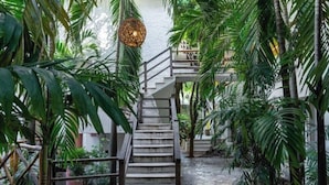 Eine Treppe, umgeben von üppigem Grün, die zu einer erhöhten Ebene führt.