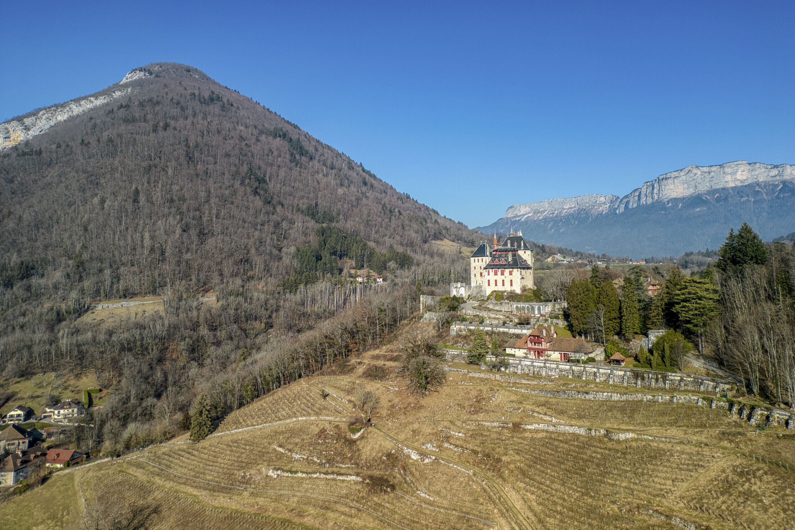 A castle-like building surrounded by a mountainous landscape.
