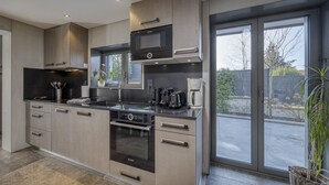 Eine moderne Küche mit eingebautem Backofen, Mikrowelle und Kaffeemaschine.