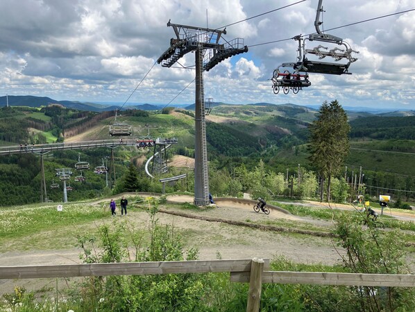 A ski lift system with gondolas and chairs, surrounded by a mountainous landscape. - Haus Postwiese - 118 m² vacation home, only 150 m from the ski lift (Winterberg)