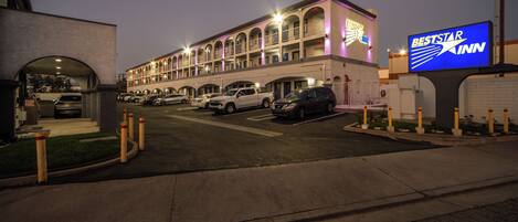 A multi-story hotel with a central courtyard, a parking lot, and a visible sign for BestStar Inn.