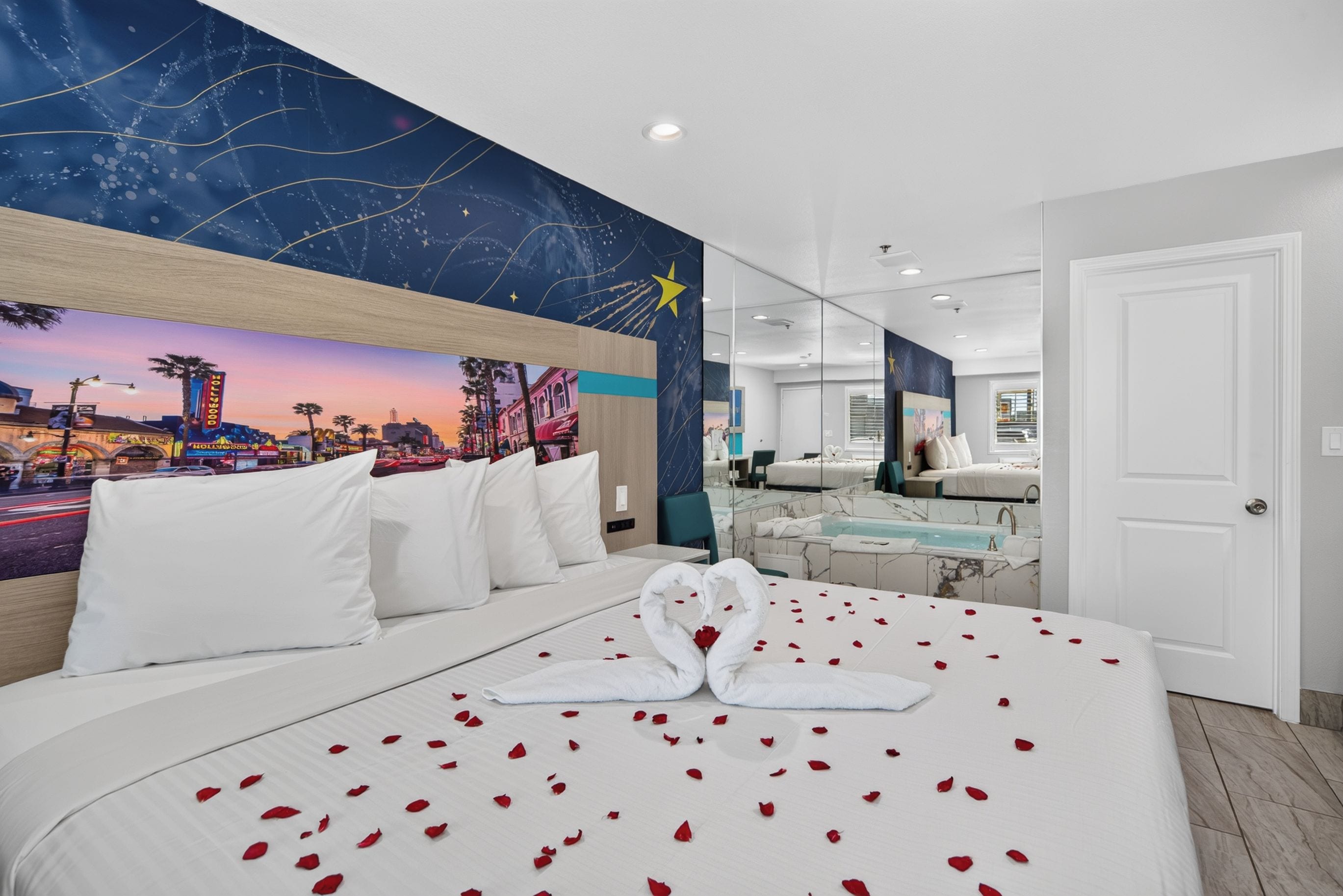 Une chambre d’hôtel avec un lit, une salle de bain et une fresque représentant un paysage urbain sur le mur.