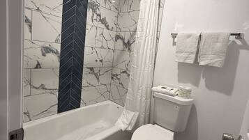 Combined shower/bathtub, towels, soap, shampoo