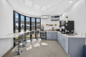 Una cocina moderna con una encimera curva, taburetes de bar y vistas a un viaducto.