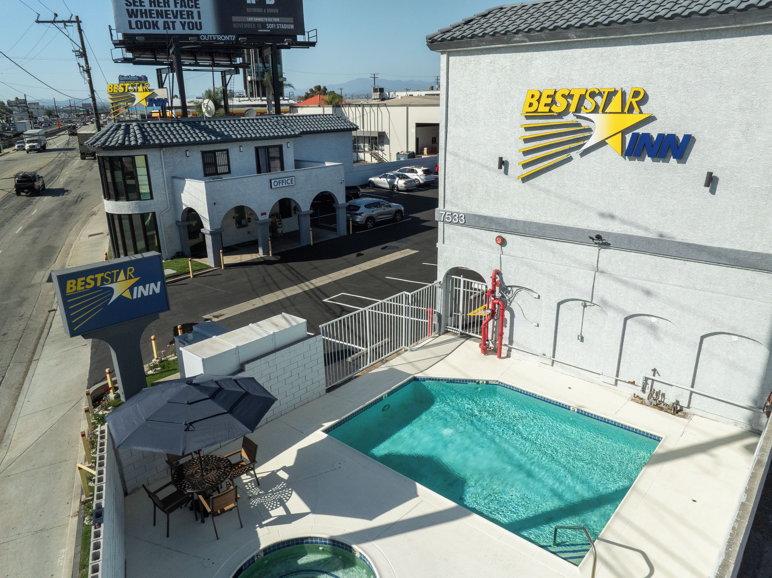 Un BestStar Inn con piscina, zona de estar al aire libre y aparcamiento visible.