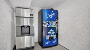 A vending machine with a blue Dodgers-themed display and a stainless steel beverage dispenser.