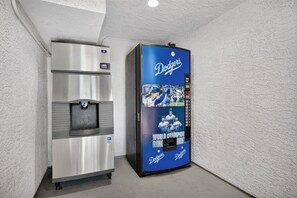 Una màquina expenedora amb una pantalla amb tema dels Dodgers blava i un dispensador de begudes d'acer inoxidable.