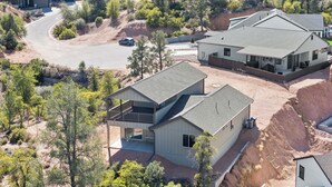 Zona residencial con casas modernas, una carretera sinuosa y abundante vegetación.